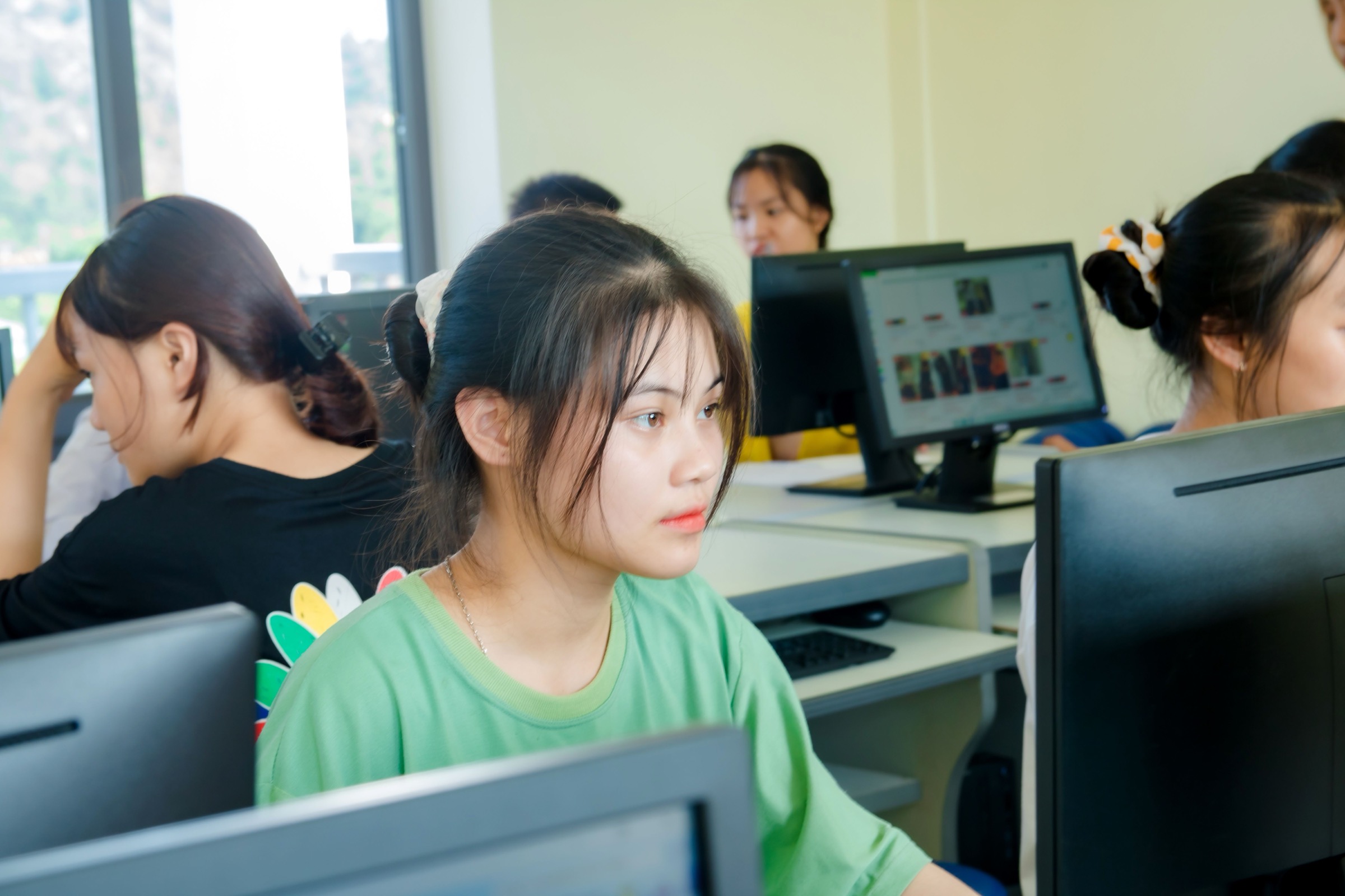 多位亚洲年轻学员在真实电脑教室进行系统训练